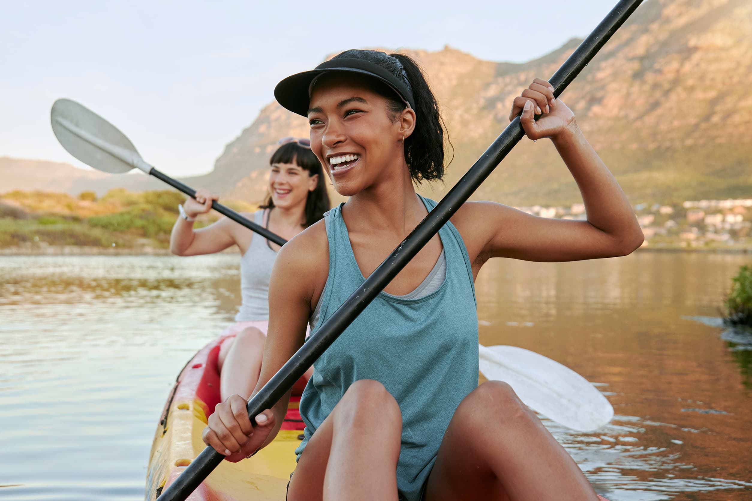 Two active, happy young women rowing a boat