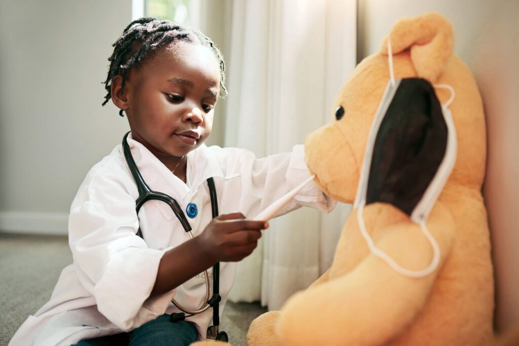 Shot of a little girl pretending to be a doctor while examining her teddybear at home stock photo