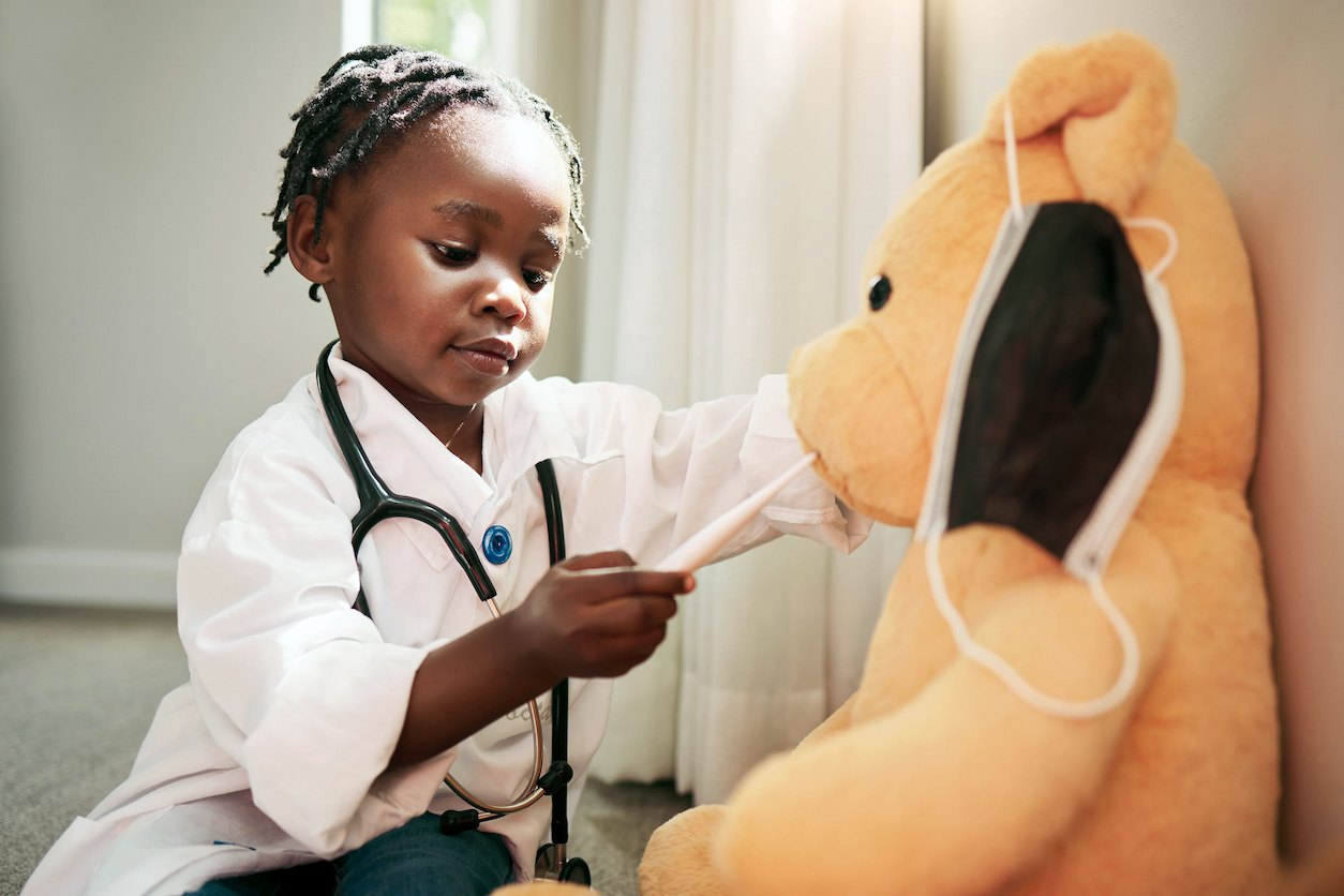 Shot of a little girl pretending to be a doctor while examining her teddybear at home stock photo