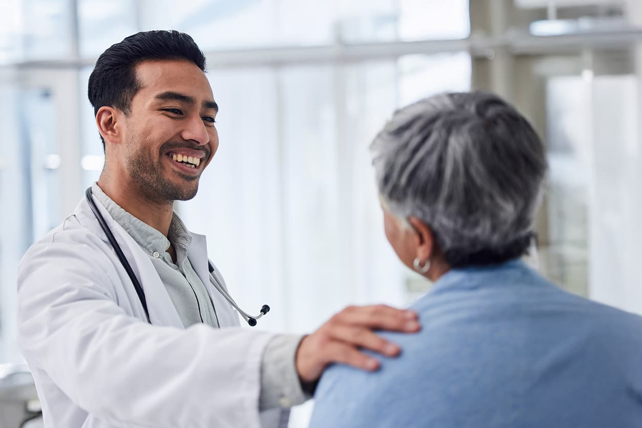 Smiling male doctor consulting patient for health advice or help at the clinic